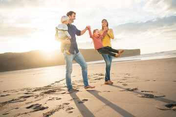 Playful family having fun with children at beach