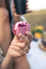  Pink macaron dessert in a man's hand, close-up. © puhimec