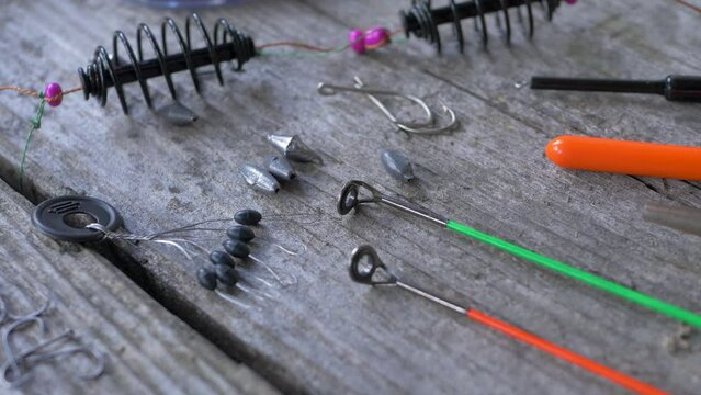 Fishing tackle on wooden background for angling. Equipment used by anglers when fishing. Hooks, sinker or knoch, fibreglass rods. Sport and recreation concept. Recreational fishing for leisure