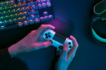 Playing computer game. Top down view of backlighted gaming accessories.