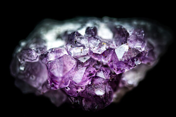 Macro close up of natural amethyst crystal cluster on black background