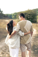 Fototapeta premium A man and a woman are walking in a field, a happy couple.