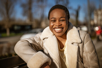 Outdoor close up portrait of happy african-american woman on sunny day.