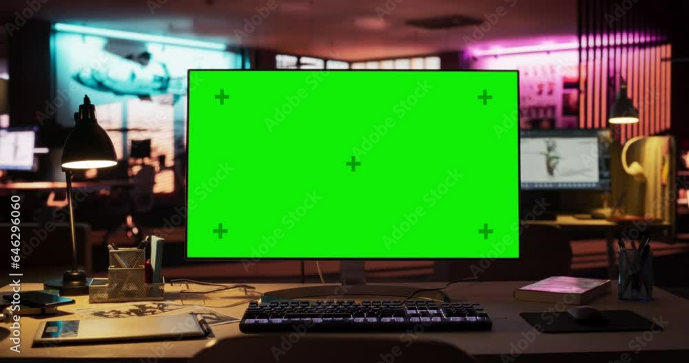 Poster Zoom In Shot of Desktop Computer Monitor Standing on a Wooden Desk with a Green Screen Chromakey Mock Up Display. Creative Office Working Station for Game Developer in Creative Agency