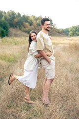 Happy mature man and woman hugging while standing in the field.