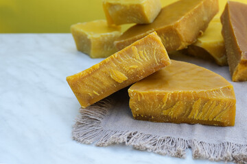 Raw beeswax. Handmade candle production. The use of beeswax in apitherapy. Production Ingredient for Medical and Cosmetics. Side view, place for text copy space.  
