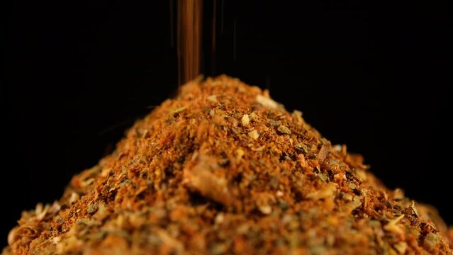 Sprinkle dry seasoning, black background. Natural seasoning for meat cooking