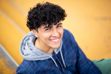 Obraz premium Close up relaxed young man sitting on steps and smiling