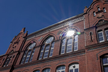 reflection of a sun in modern window installed in an old gothic building