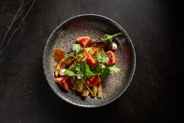 Poster Horizontal top view of roasted eggplant with tomatoes, cilantro, and cheese on a stone plate, set against a minimalist black marble background, embodying pan-Asian flavors © Ryzhkov