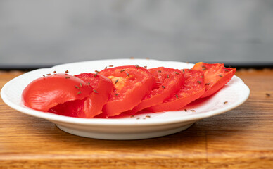Lot of fruit flies Drosophila melanogaster eating of slices of tomatoes in home kitchen.