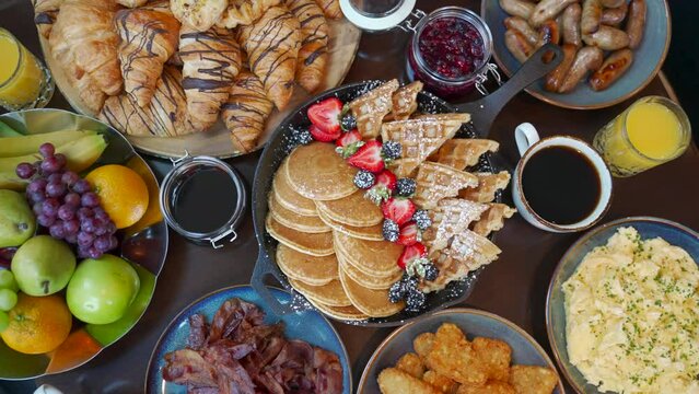 Buffet of breakfast food, including eggs, coffee, juice, bacon and potatoes