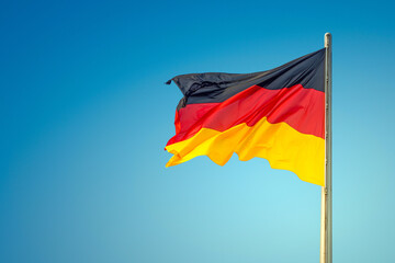 National black red yellow flag of Germany and at blue sky gradient background with copy space at...