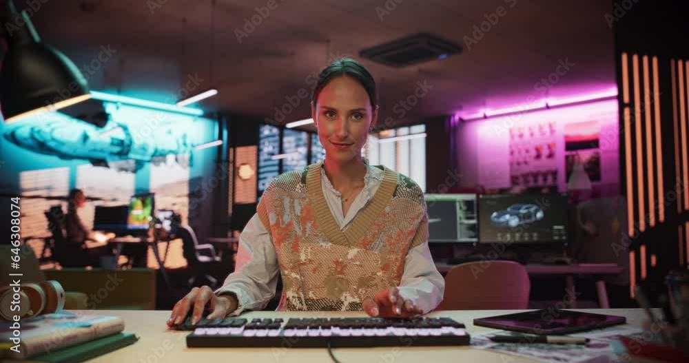 Poster Portrait of a Female Software Developer Writing Code in a Creative Office with Neon Lights. Young Woman Focused on Typing on Keyboard and Working on Desktop Computer. Point of View of Screen Monitor