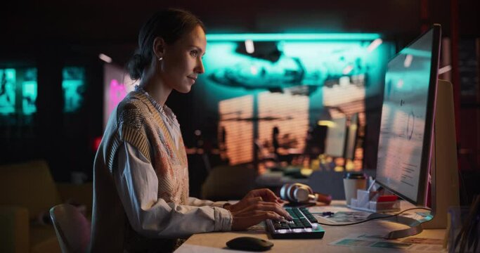 Female Talented Digital Marketing Specialist Working on Computer at Office in the Evening. Young Caucasian Businesswoman in Creative Agency, Smiling and Researching Business Analytical Data