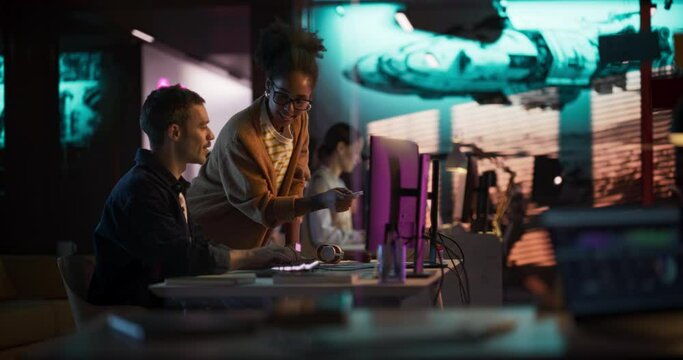 Portrait of Black Creative Director Giving Instructions on 3D Game Visuals to Male Developer in Creative Agency. Two Stylish Diverse Employees Discussing Design on Computer. Slow Motion