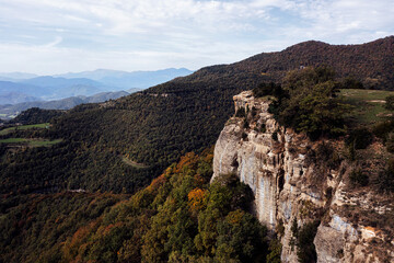 Obraz premium aerial view of the wall of a cliff in a mountain forest, concept of nature and adventure tourism, copy space for text