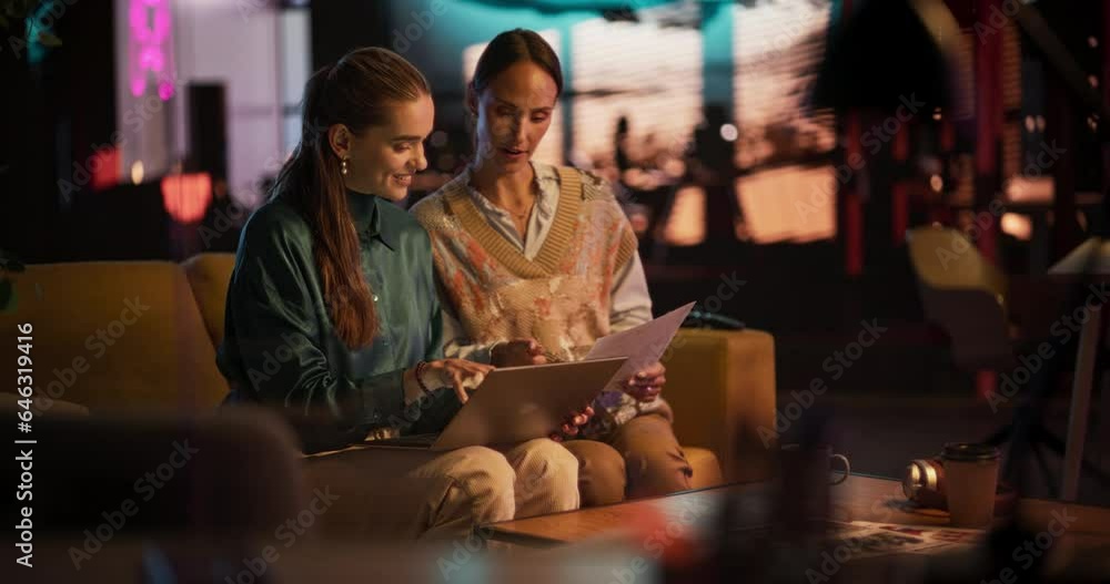 Poster Slow Motion: Portrait of Two Female Creative Colleagues Collaborating and Pointing at the Laptop Screen in Office Hub. Lead Designer Discussing Work with Assistant and Choosing Marketing Strategy