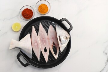 Fresh whole Silver Pomfret fish or butter fish or Poplet cut into slices. cleaned and ready for frying along with spices. ingredients and recipe background with copy space
