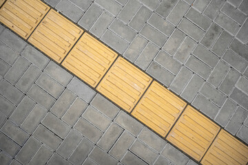 Way or line laid of yellow tactile tiles, top view.
