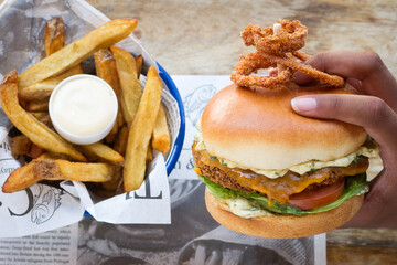 Crab burger in the hand with homemade fries in restaurant