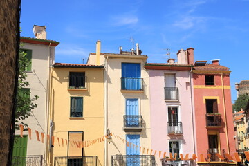Fototapeta na wymiar Colourful house fronts against backdrop of blue sky in Collioure, a Mediterranean seaside town in south of France