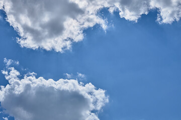 two white clouds in a blue sky