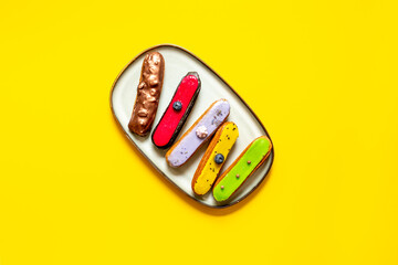 Set of various glased eclairs with chocolate and berrie, top view