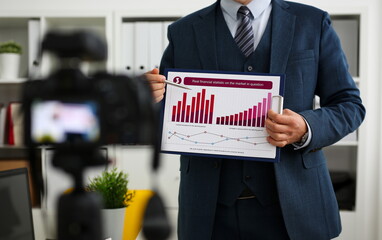 Male in suit and tie show stats graph pad making promo videoblog or photo session in office...