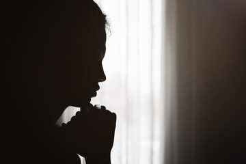 Silhouette of  Christian life crisis prayer to god.  woman hands praying to god. begging for...