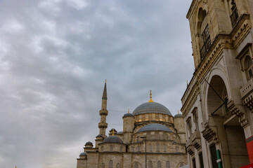 Fototapeta na wymiar Eminonu New Mosque or Yeni Cami with cloudy sky. Travel to Istanbul