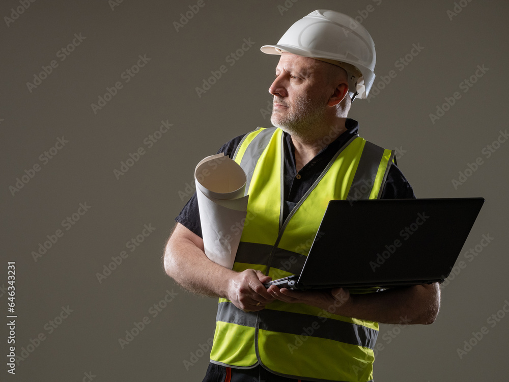 Poster man engineer. worker with laptop. guy in builder uniform. engineer in hardhat looks away. man with a