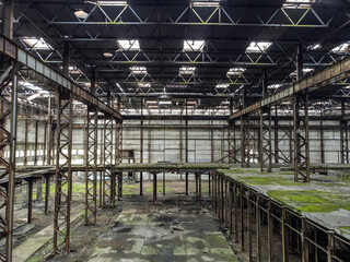 Old abandoned plant. Building former industrial enterprise. Interior of abandoned plant. Industrial hangar with rust and mold. Abandoned plant with metal structures inside. Former warehouse building