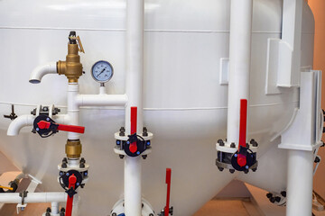 Pipes and gauges on industrial tank. Gas equipment. Valves for pressure control. White industrial...