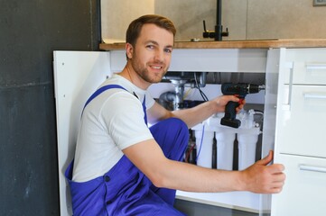 kitchen installation. Worker assembling furniture