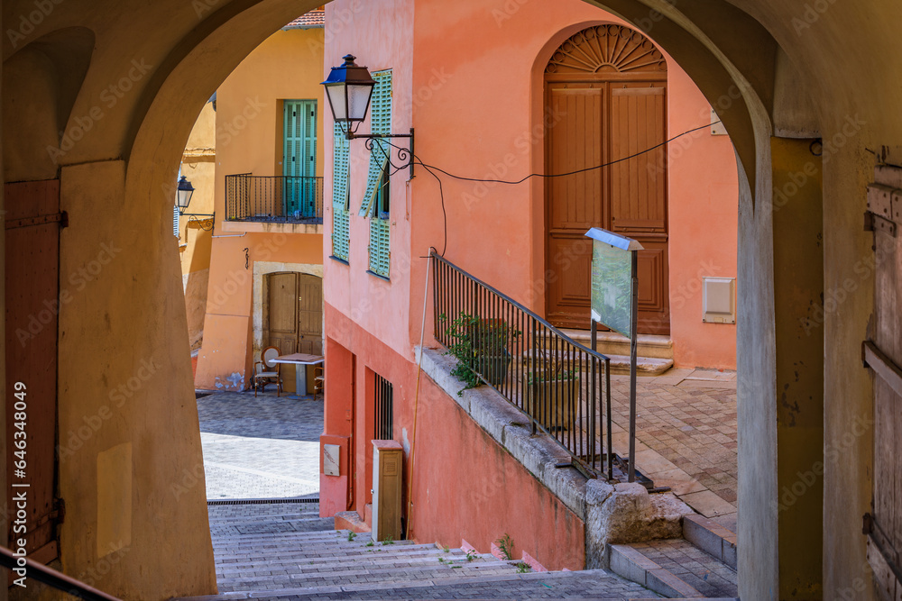 Sticker Picturesque arch on a narrow street with colorful traditional houses in the old town of Menton on the French Riviera, South of France