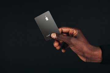 Earning private banking rewards with cashless payments: Man using his black credit card at checkout