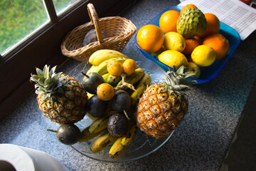 A lot of tropical fruits in a glass vase. Exotic fruits: averrhoa carambola, Pitahaya, Mango,...
