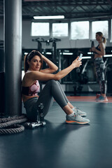 Fototapeta na wymiar Sporty lady making pause in a gym after exercise.