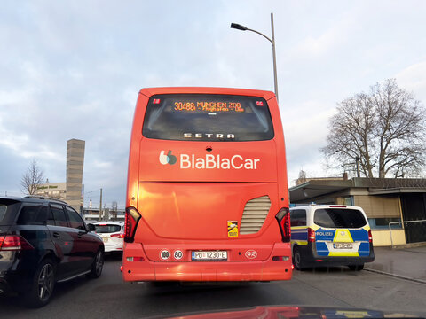 Kehl, Germany - FEb 18, 2023: An image of the red BlaBlaCar coach bus heading to Munich, captured from the rear, showcases the journey's starting point - police van for control