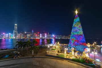 Scenery of Christmas tree and decoration with skyline of Victoria harbor of Hong Kong city - obrazy, fototapety, plakaty