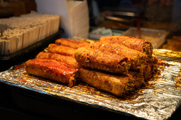 Grilling barbecue meatloaf rolled with vegetables at traditional night market in South Korea.