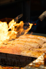 Grilling barbecue meatloaf rolled with vegetables at traditional night market in South Korea.