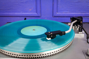 Close up of vintage turntable vinyl record player with turquoise vinyl