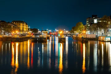 Foto op Plexiglas Illuminated Canals and Riverside Delights: Exploring Amsterdam After Dark. Captivating Cityscape of Amsterdam at Night: A Delightful Blend of Tradition and Modernity © Ilja