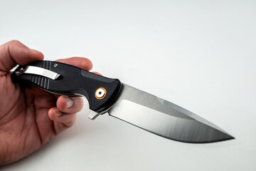 closeup hand holding a tanto combat knife isolated on white