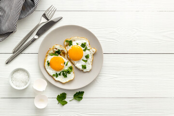 Cooking fried eggs for fast breakfast, top view. Food background