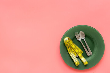 Body weight control concept with empty plate and cutlery, top view