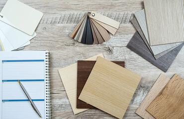 Workplace of designer empty notepad with pen and wooden color palettes samples