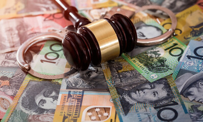 Judge's gavel with handcuffs on australian dollars